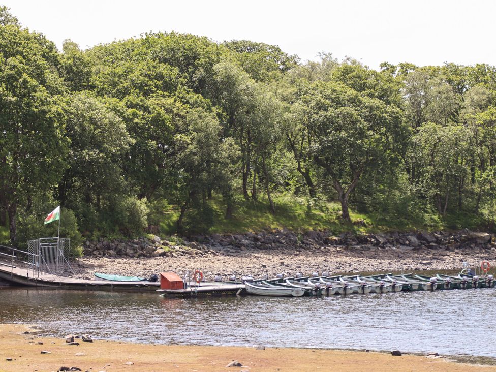 A pier with boats and trees at Babbling Brook in Bron Aber near Blaenau Ffestiniog