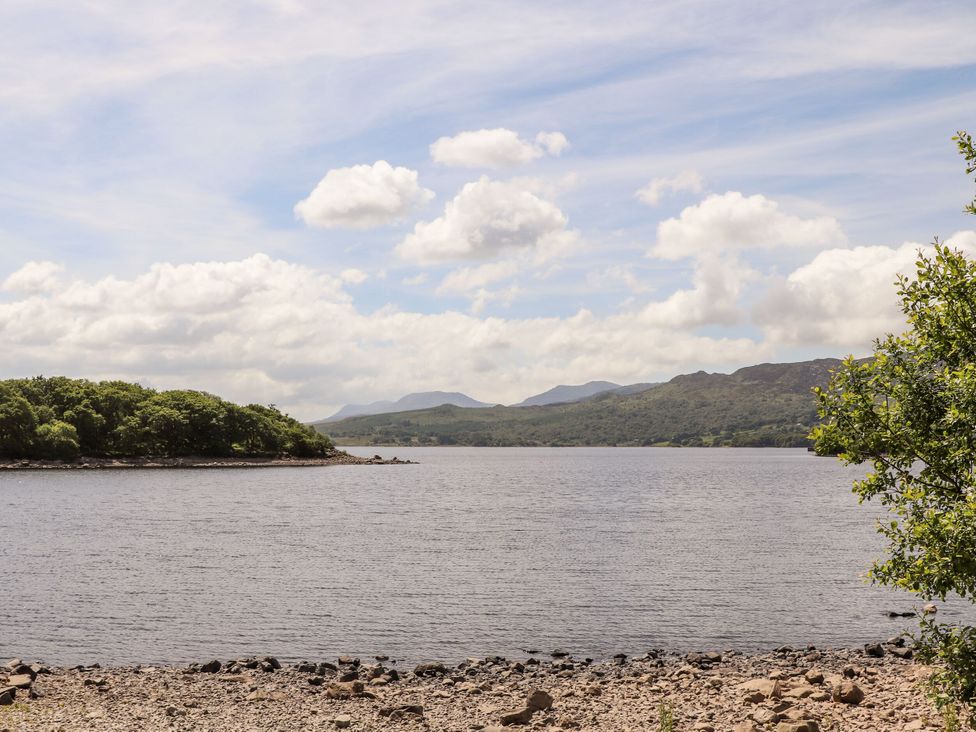 A lake with an island and mountains in the background at Babbling Brook near Blaenau Ffestiniog