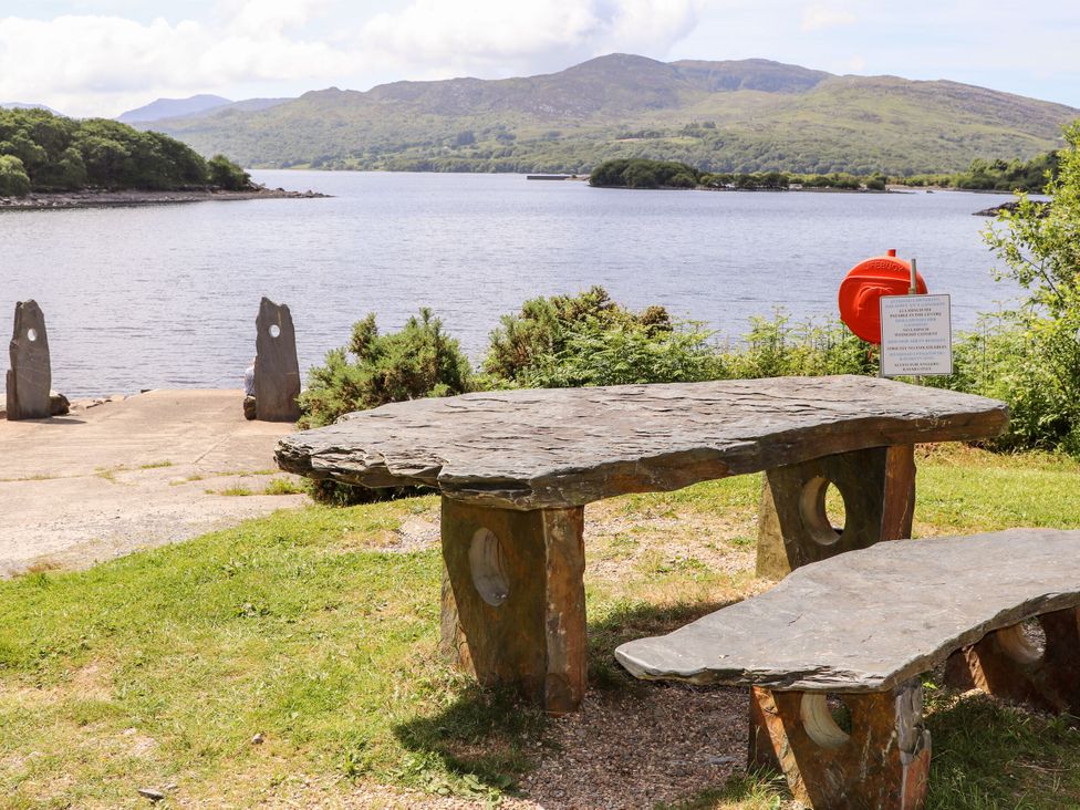 A table and bench near a lake with a life buoy at Babbling Brook near Blaenau Ffestiniog