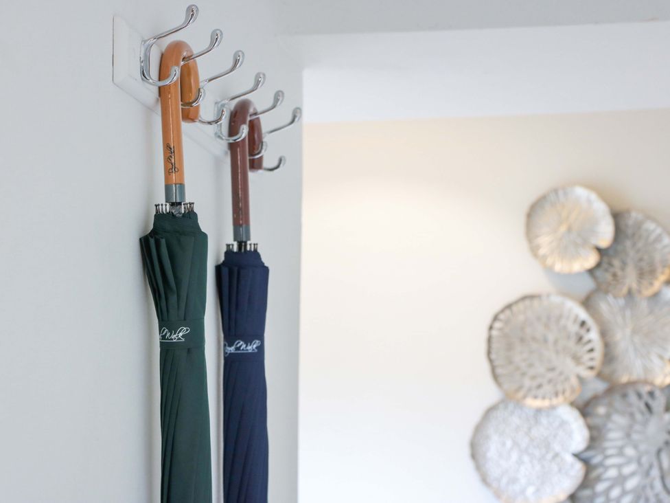 Umbrellas hanging on a wall hook in an entryway at Clocktower - Culzean Castle Maybole