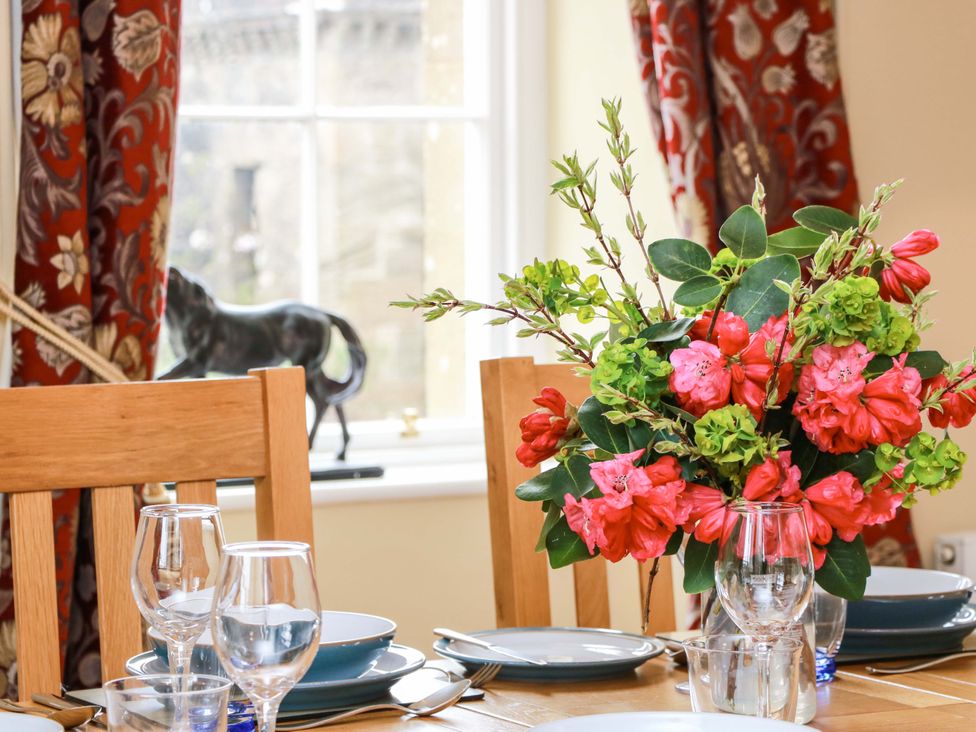 A dining room table with flowers and settings at Clocktower - Culzean Castle in Maybole