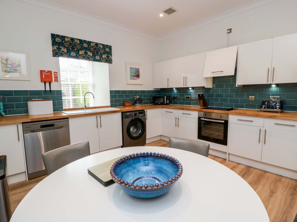 A kitchen with appliances and a dining table at Clocktower - Culzean Castle in Maybole
