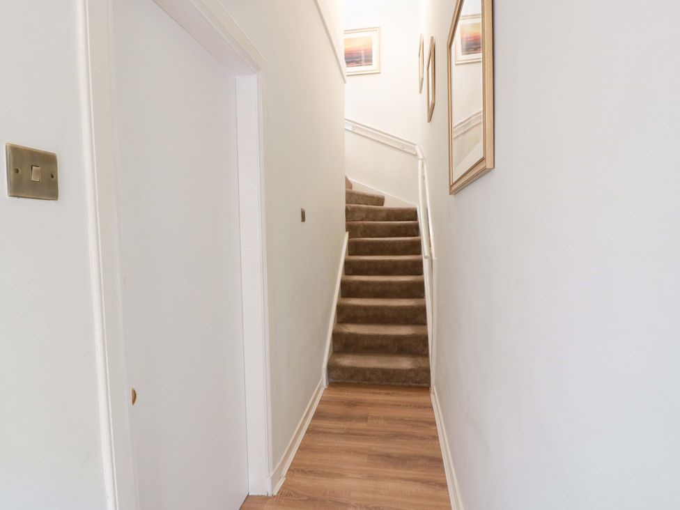 A staircase with framed artwork in a hallway at Clocktower - Culzean Castle in Maybole