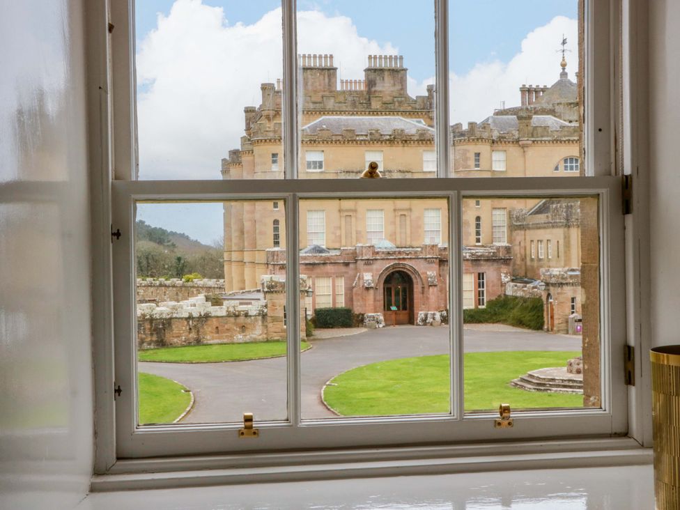 A view from a window showing a building and lawn at Clocktower - Culzean Castle Maybole