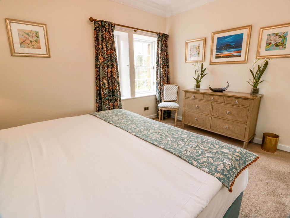 A bedroom with a bed, dresser, chair and decorative items at Clocktower - Culzean Castle in Maybole