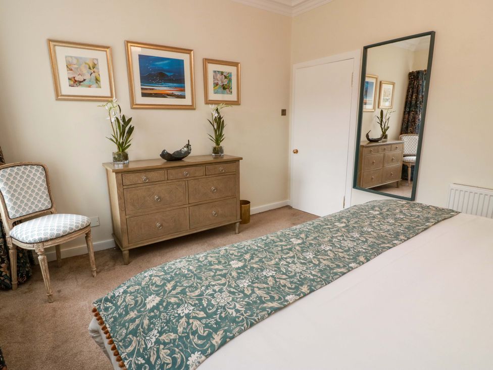 A bedroom with a bed, mirror, and dresser at Clocktower - Culzean Castle in Maybole