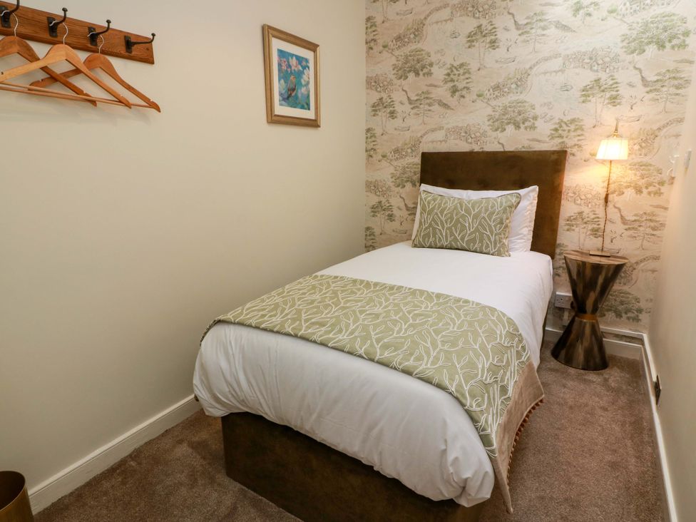 A bedroom with a single bed and coat rack at Clocktower - Culzean Castle in Maybole