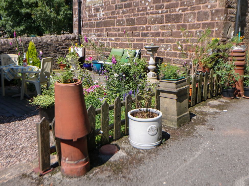 A garden with flowers, pots and seating area at The Netty in Flash