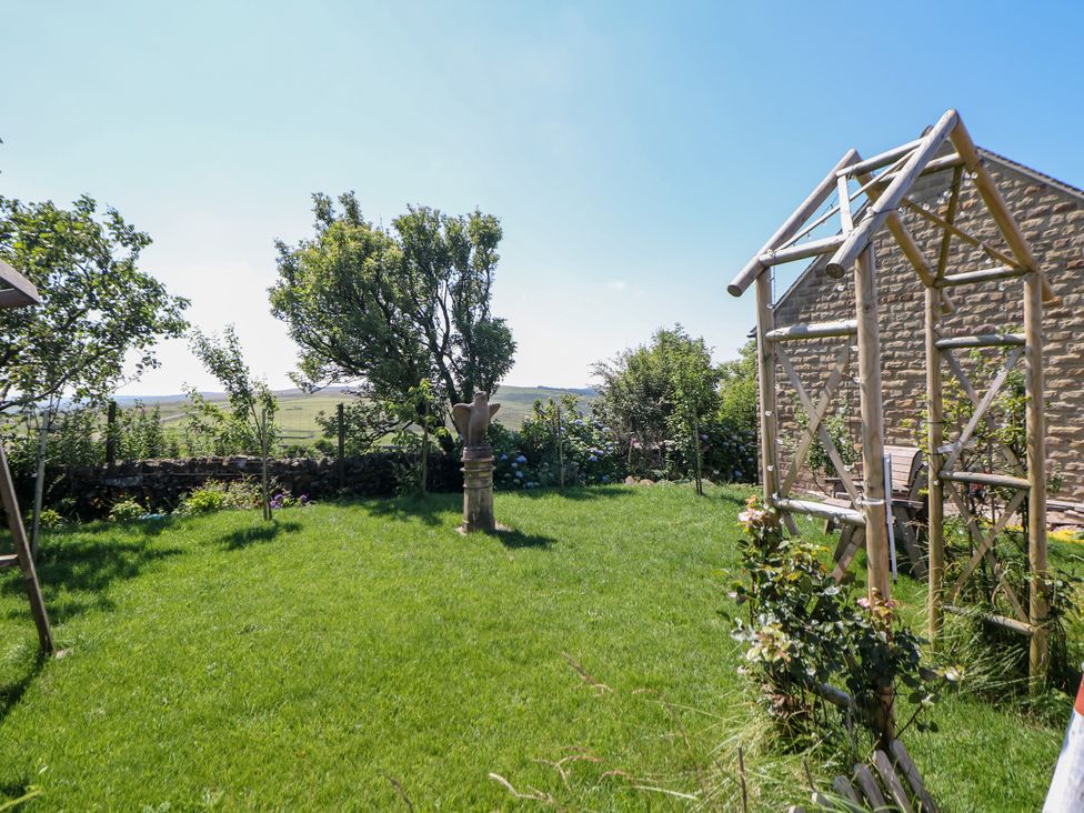 A garden with grass, trees, and a climbing frame at The Netty in Flash