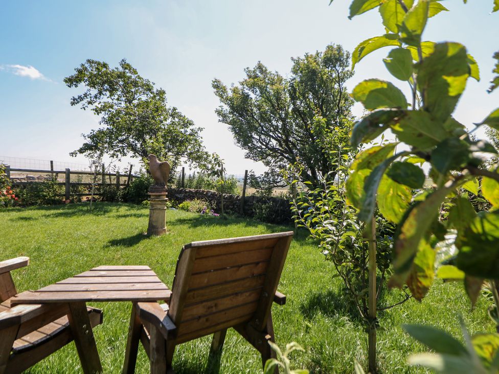 A garden with grass, chairs, trees, and a statue at The Netty in Flash