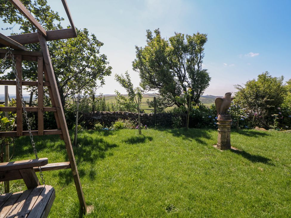 A garden with a swing set and stone sculpture at The Netty in Flash