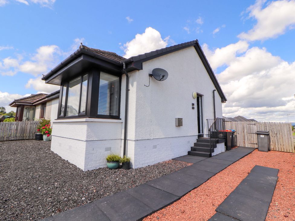 A house with steps, a satellite dish, and a garden at The Paddock in Kirkcowan