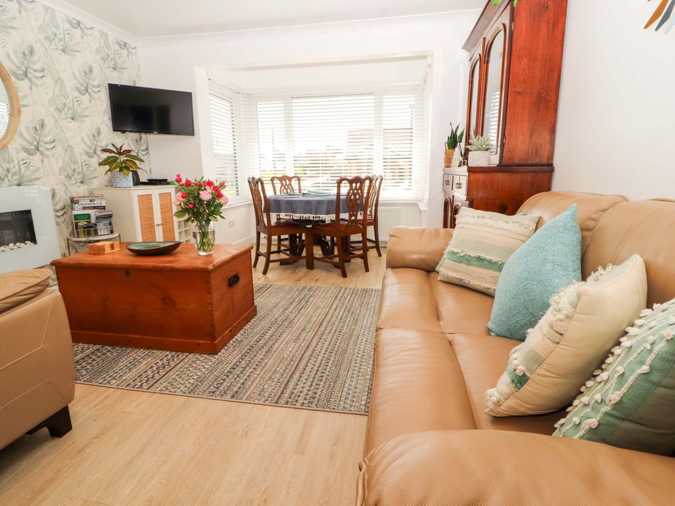 A living room with a sofa and a dining table at The Paddock Kirkcowan