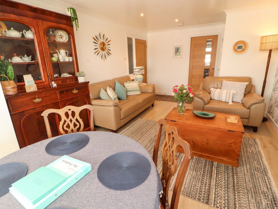 A living room with a coffee table and display cabinet at The Paddock in Kirkcowan