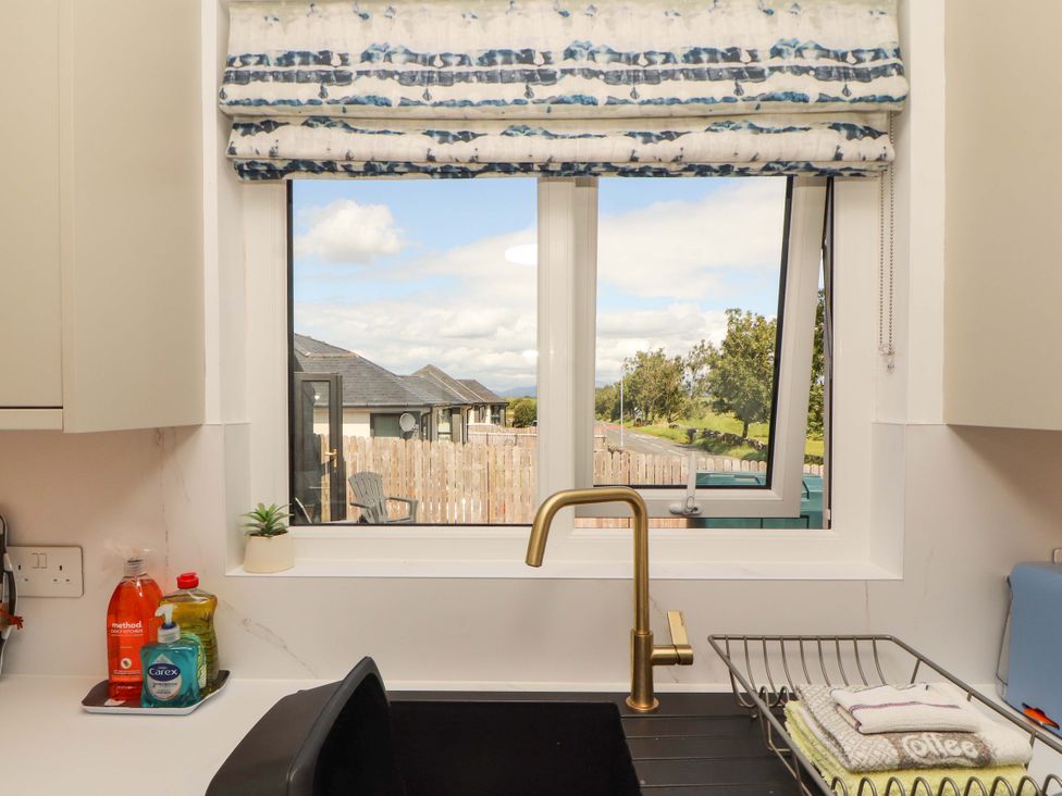 A kitchen with a sink and window showing outdoor view at The Paddock in Kirkcowan