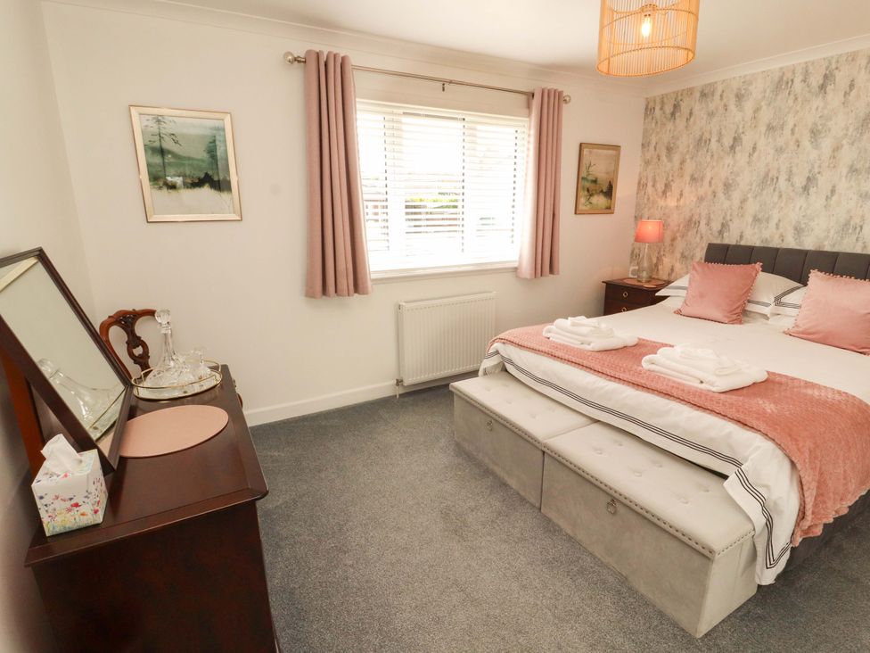 A bedroom with a bed and side table at The Paddock in Kirkcowan