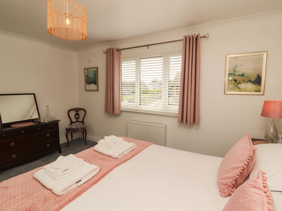 A bedroom with a bed and dresser at The Paddock in Kirkcowan