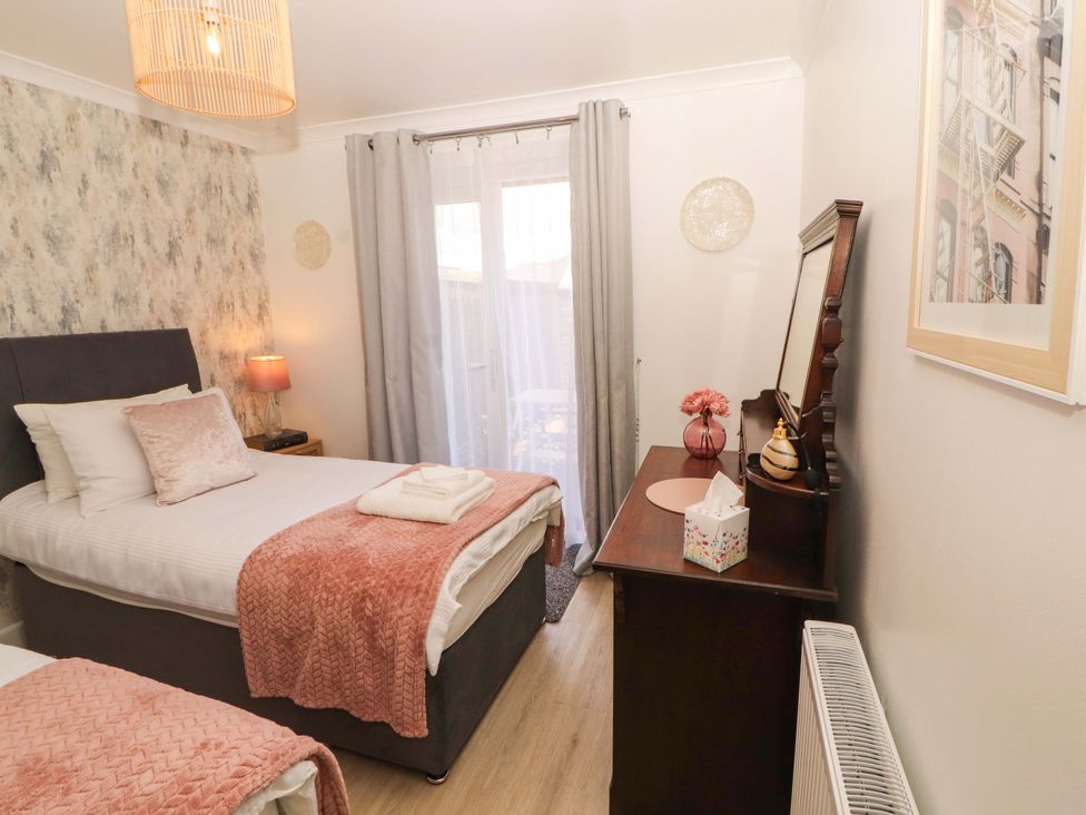 A bedroom with two beds and a dresser at The Paddock in Kirkcowan