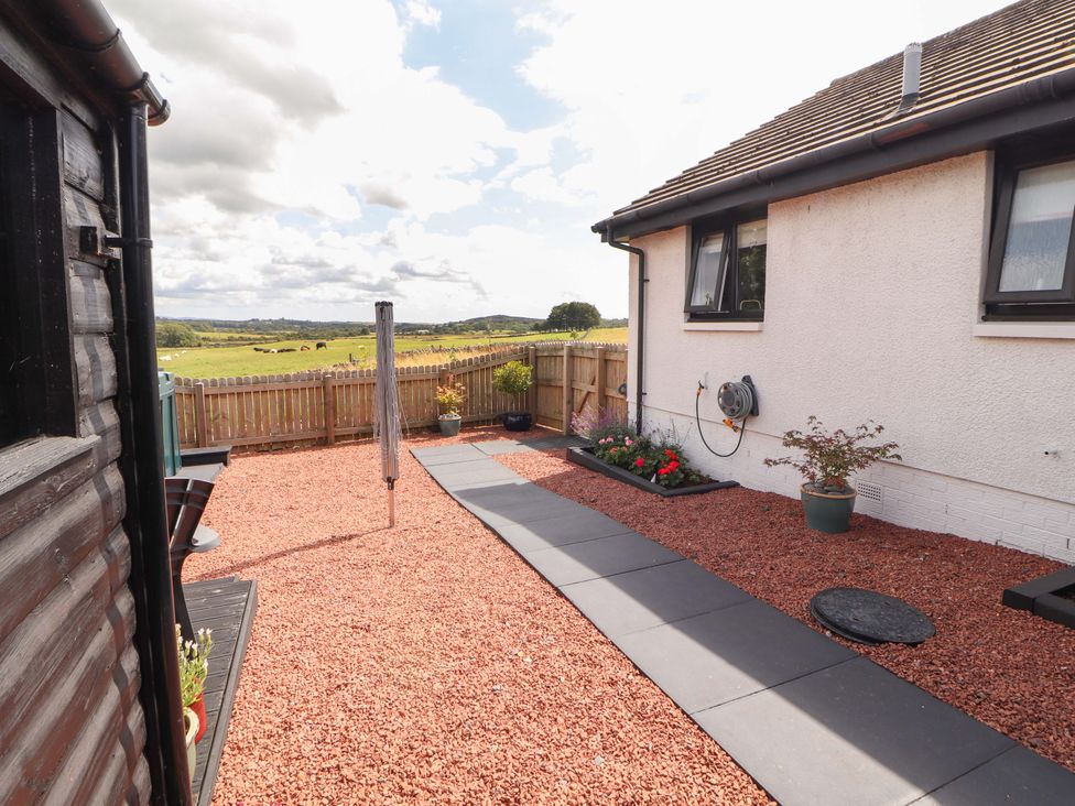 A garden with a pathway and flower pots at The Paddock in Kirkcowan