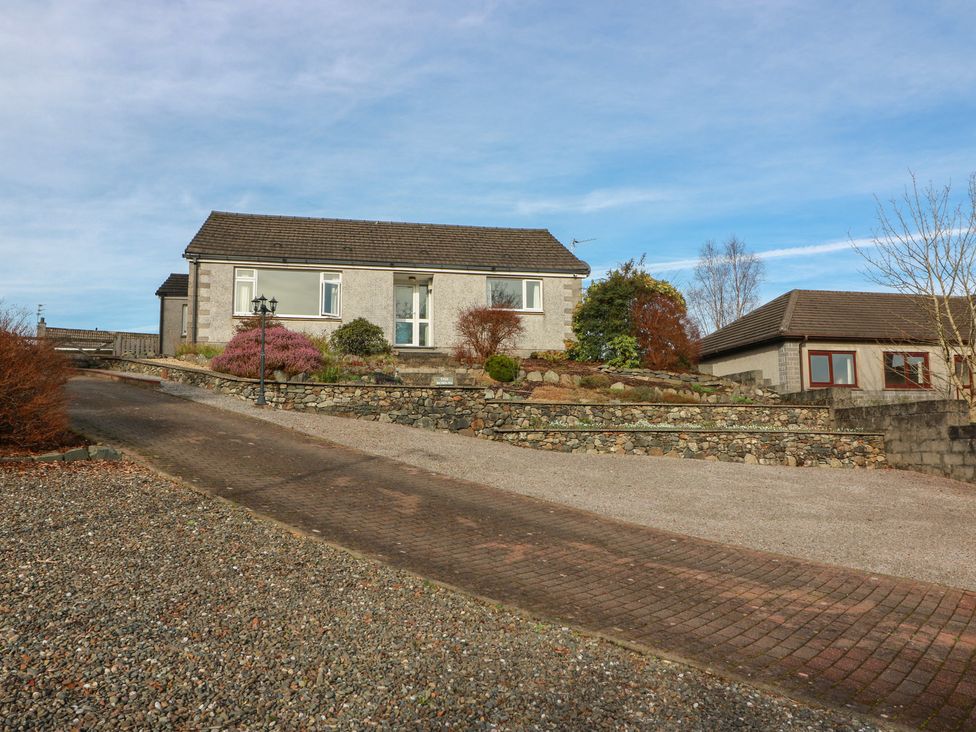 A house with a driveway and garden at The Rowans in 