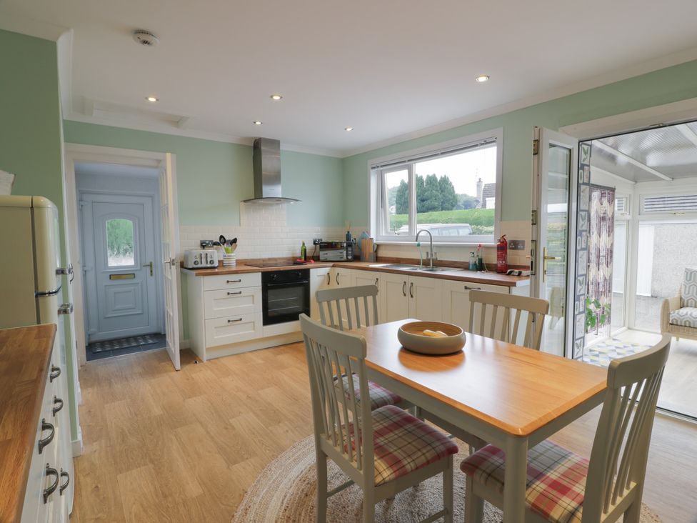 A kitchen with dining table and chairs at The Rowans in 