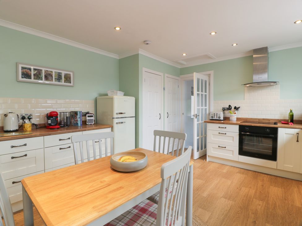 A kitchen with a table and chairs at The Rowans