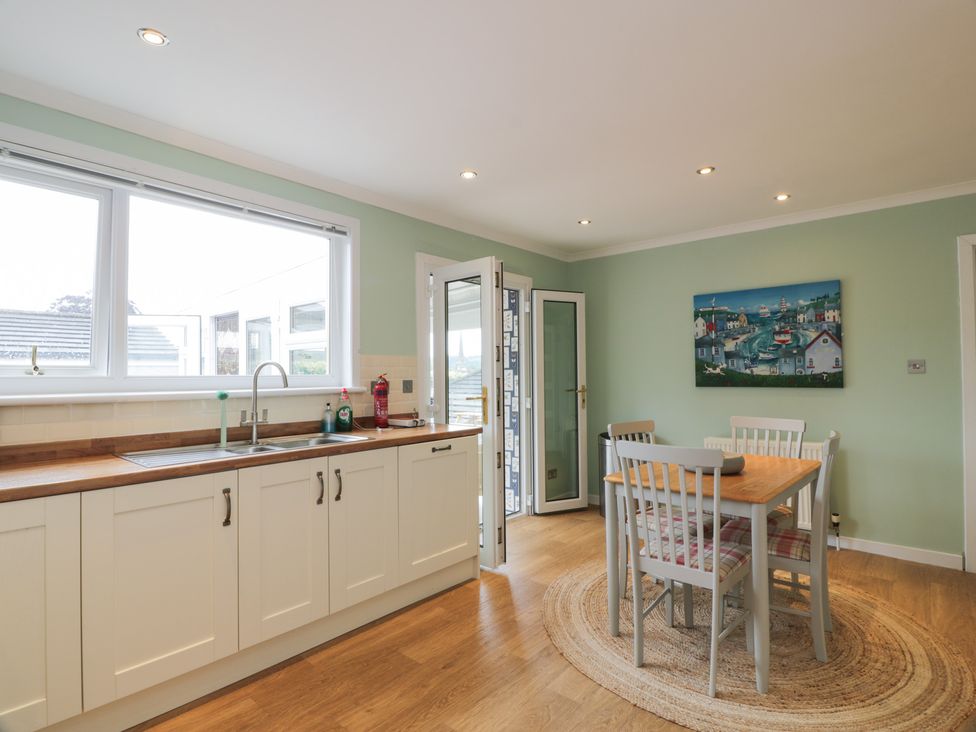 A kitchen with a table and chairs at The Rowans in 