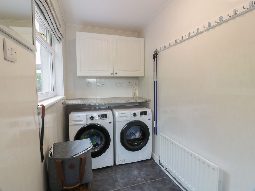 A laundry room with washing machine and dryer at The Rowans