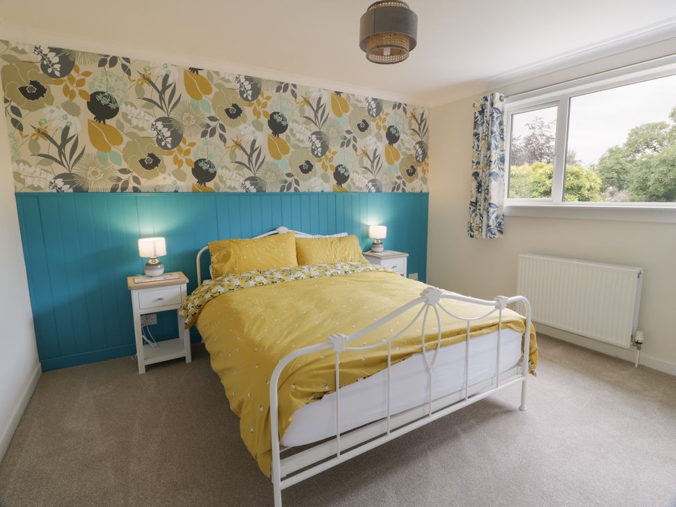A bedroom with a bed and bedside tables at The Rowans in 