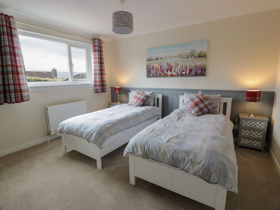 A bedroom with two single beds and a window at The Rowans in 