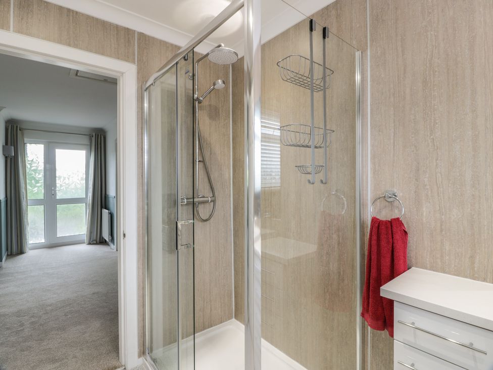 A bathroom with a shower and red towel at The Rowans in 