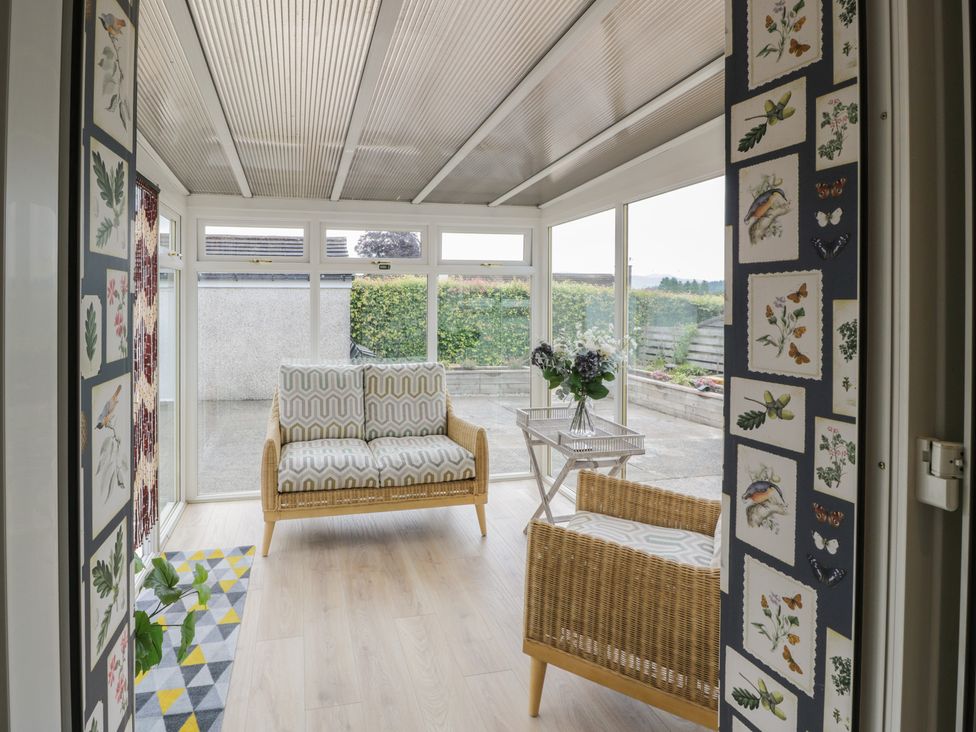 A conservatory with seating and plants at The Rowans in 