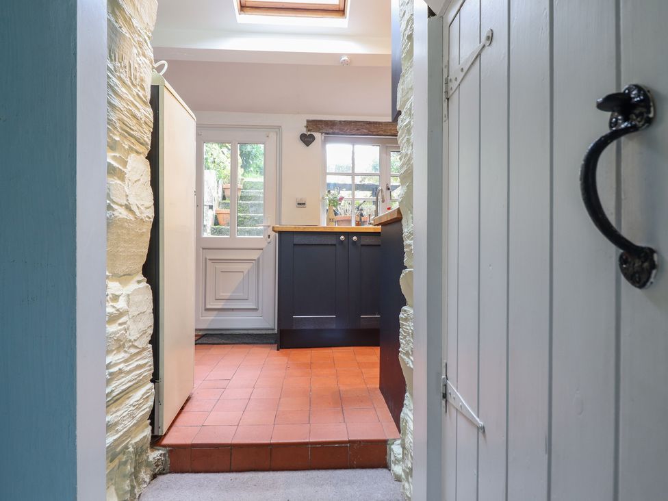 A kitchen entry with cabinets and a window at Preswylfa in Ffestiniog