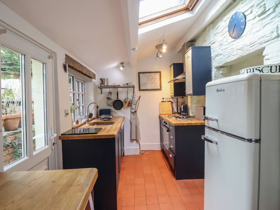 A kitchen with a fridge, stove, and sink at Preswylfa in Ffestiniog