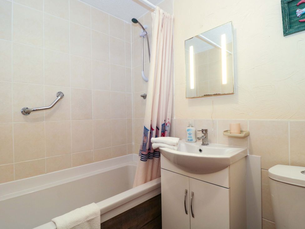 A bathroom with a bathtub, sink, and toilet at Owls Retreat in Brean