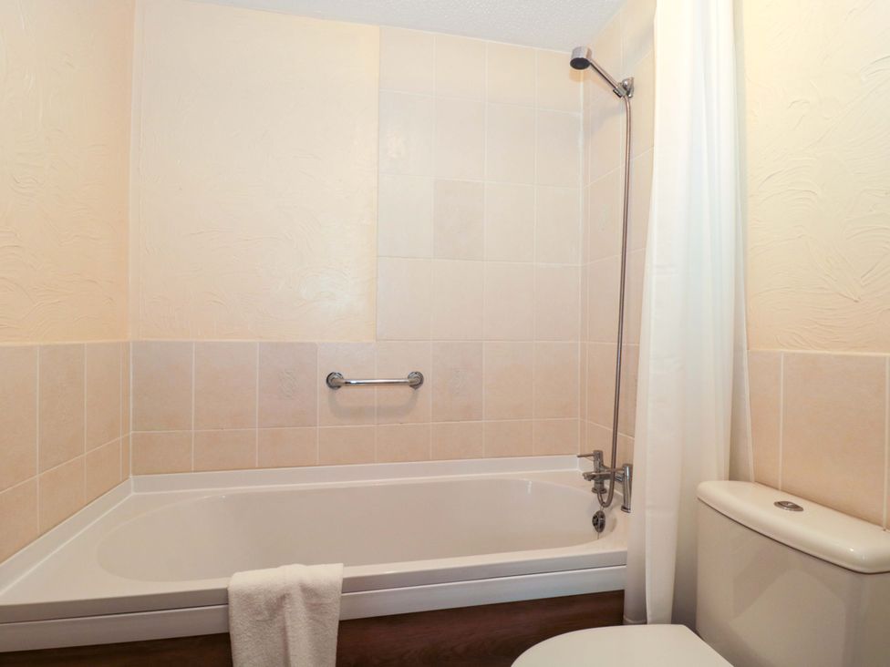 A bathroom with a bathtub and a toilet at Owls Retreat in Brean
