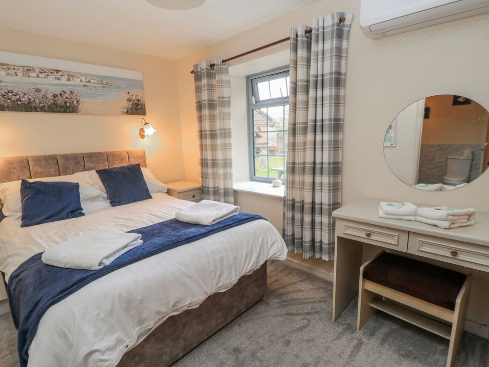 A bedroom with a bed and desk at Carthouse in Brean