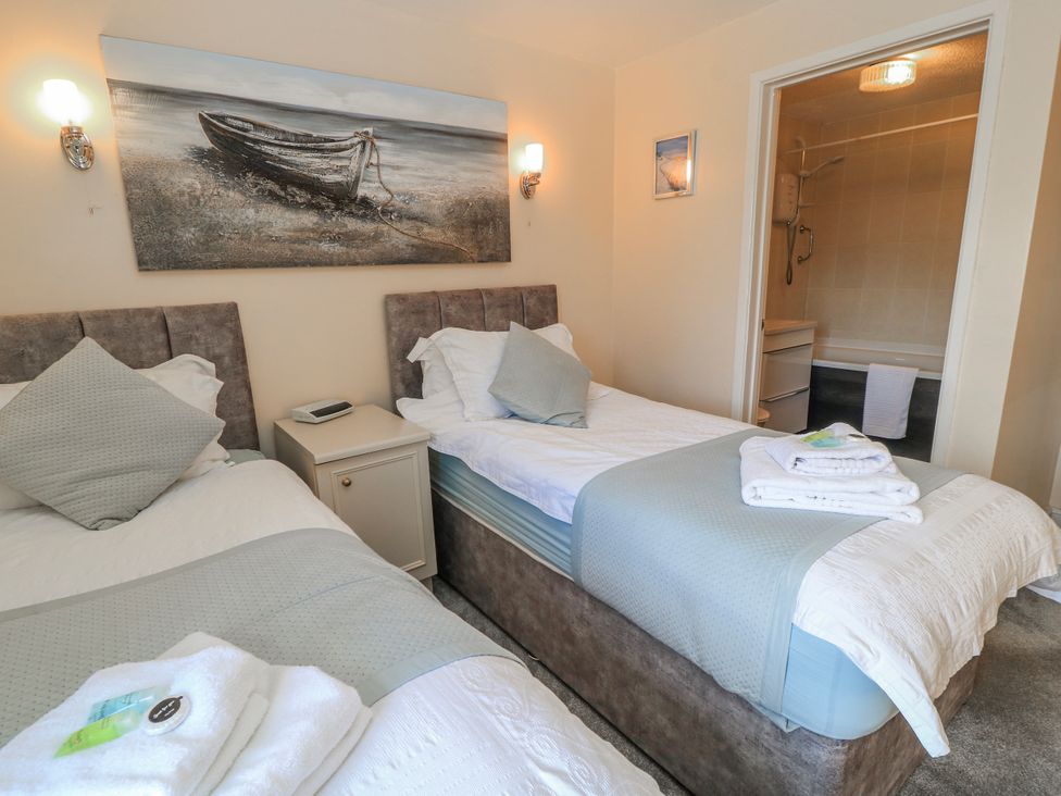 A bedroom with two beds and a bathroom at Carthouse in Brean