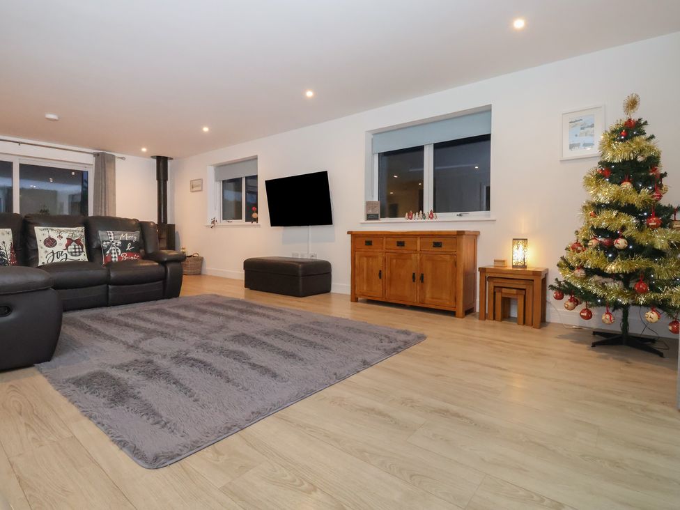 A living room with a sofa and Christmas tree at 3 Praa Cove in Praa Sands
