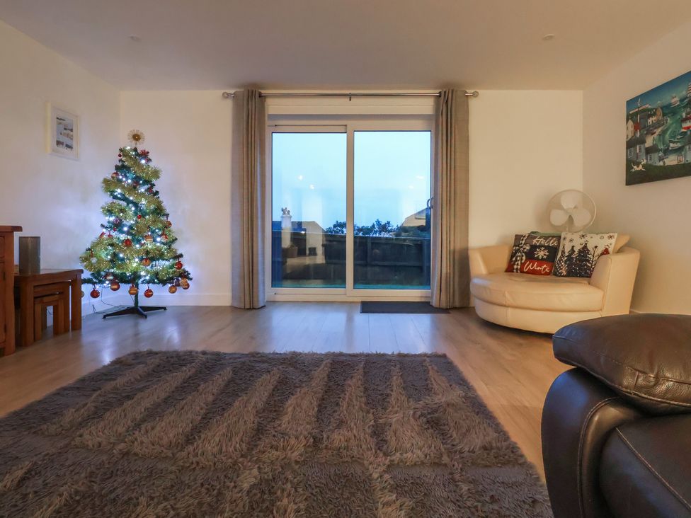 A living room with a Christmas tree and sliding door at 3 Praa Cove in Praa Sands