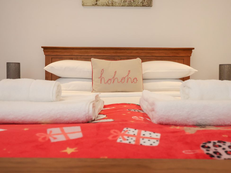 A bedroom with a bed, pillows, and towels at 3 Praa Cove in Praa Sands