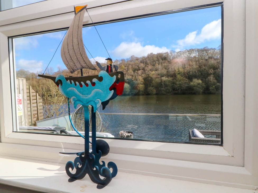 A sailboat figurine on a window sill overlooking a lake at The Bothy in Leek