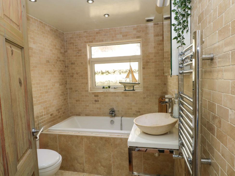A bathroom featuring a bathtub, toilet, and sink at The Bothy in Leek