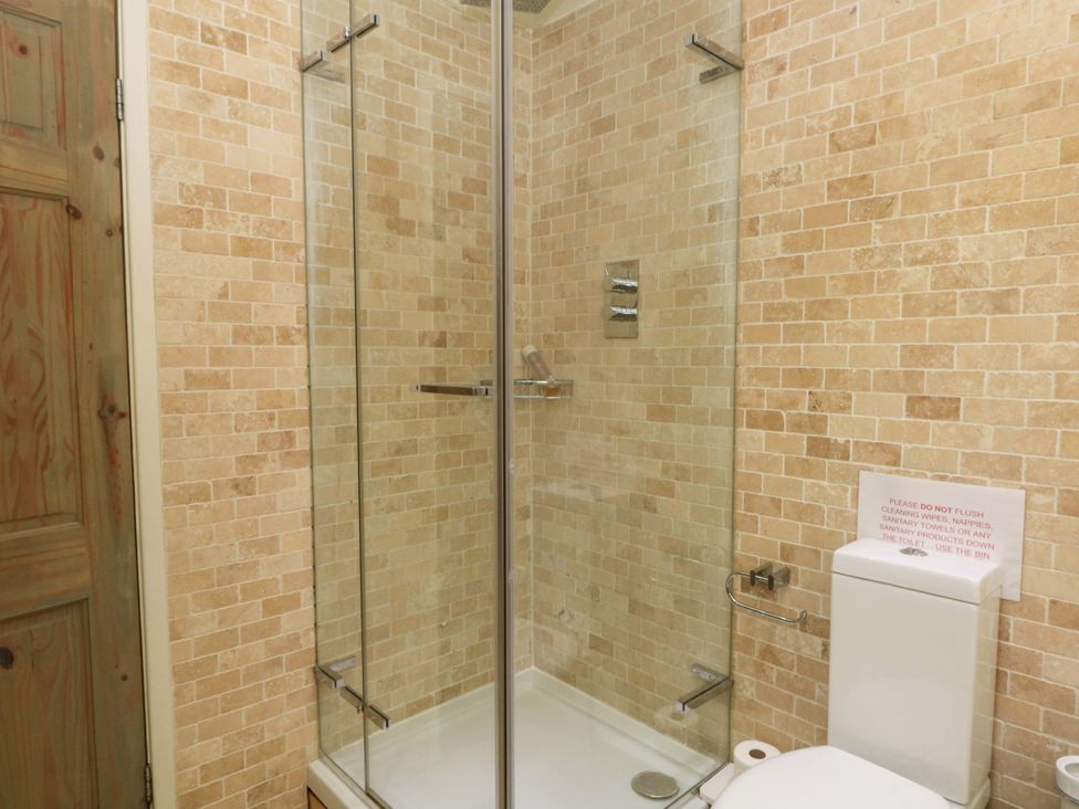 A bathroom with a shower enclosure and toilet at The Bothy in Leek