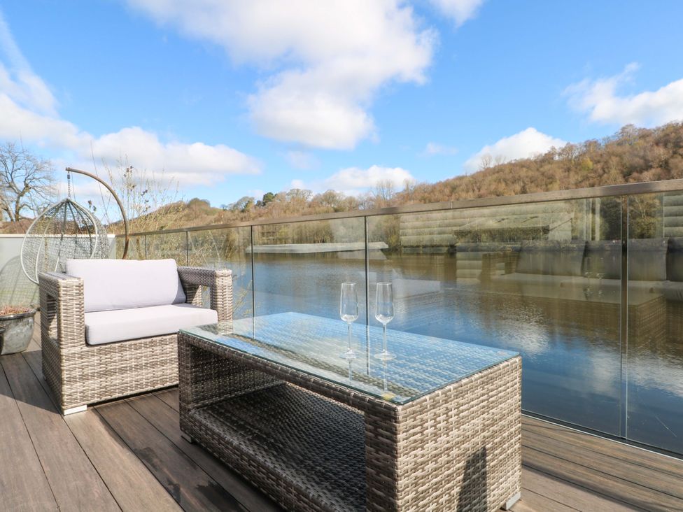 A balcony with outdoor furniture and a view of the water at The Bothy in Leek