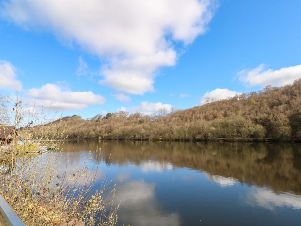 A river with trees and hills under a blue sky at The Bothy in Leek
