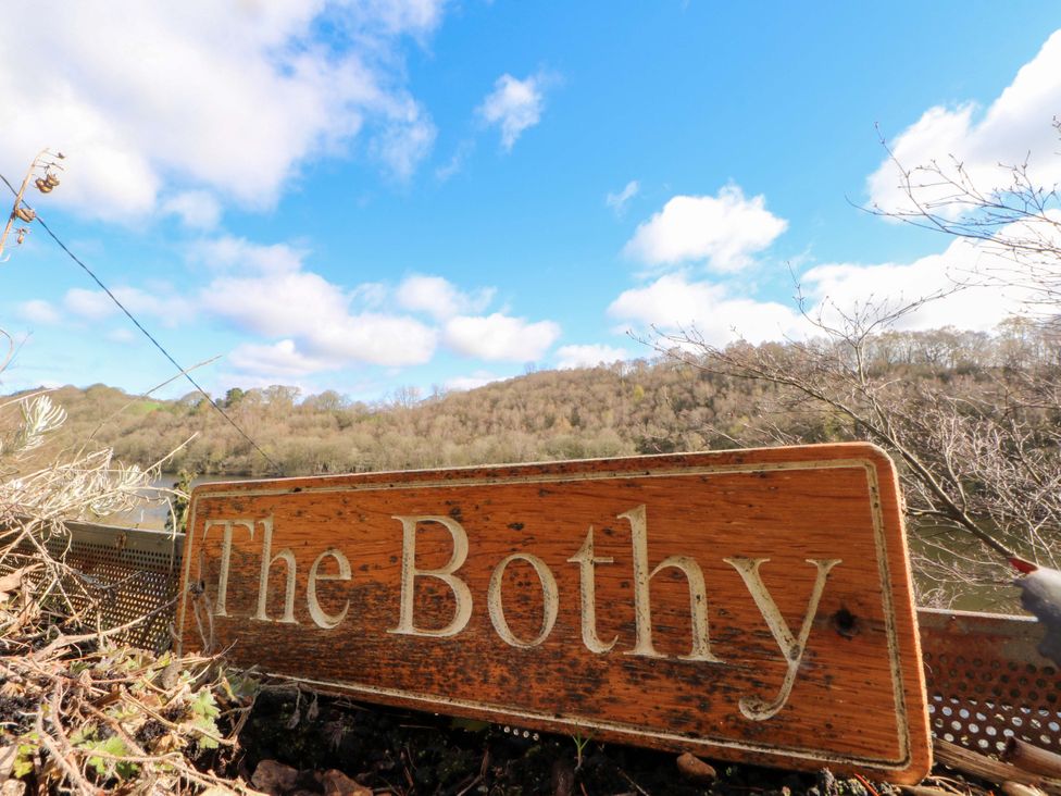 A sign for The Bothy with a view of a hill and water in Leek