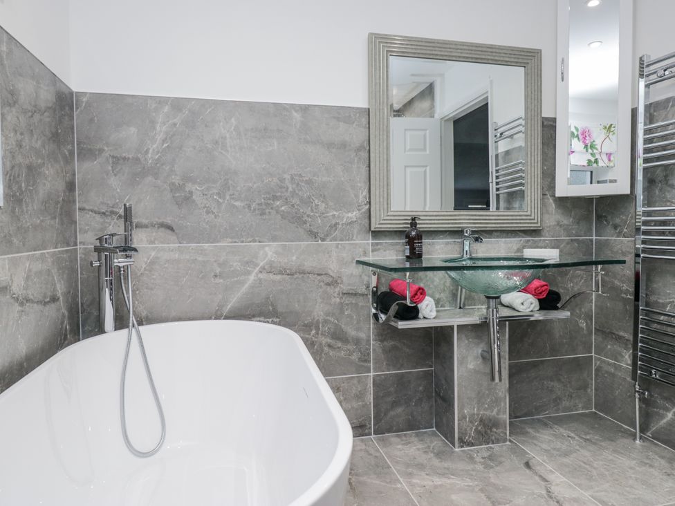 A bathroom with a bathtub and a sink at Hazelodge in Coniston