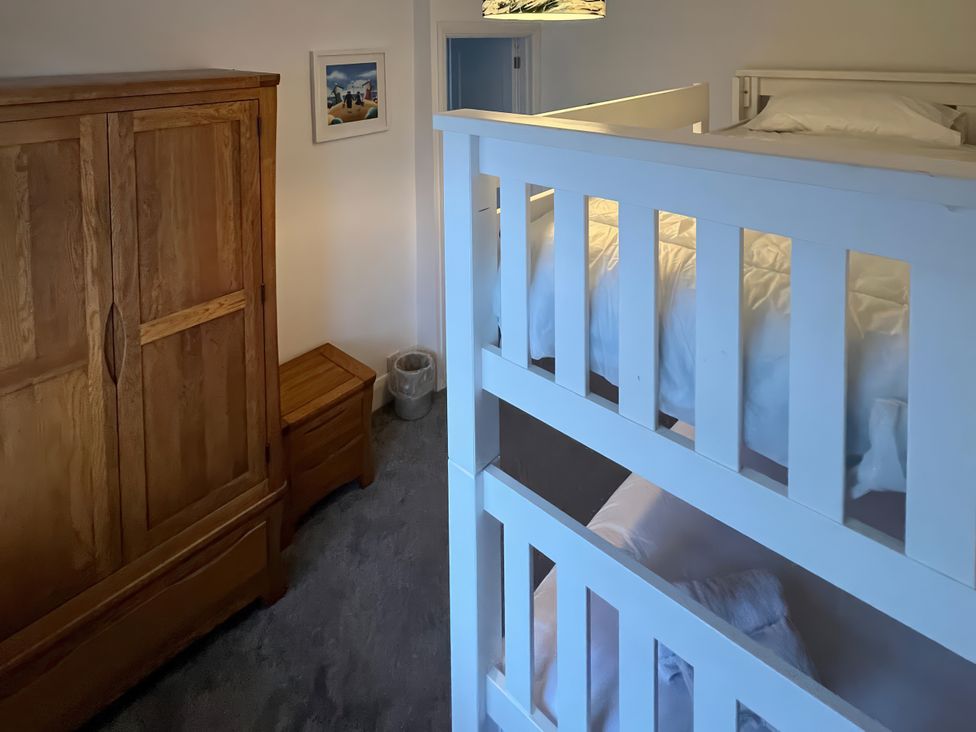 A bedroom with bunk beds and a wardrobe at Greenbank in Woolacombe
