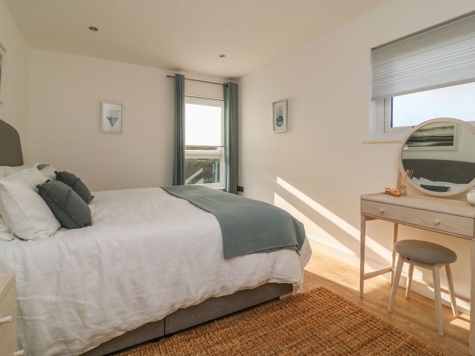 A bedroom with a bed and a dressing table with a mirror at The Lookout